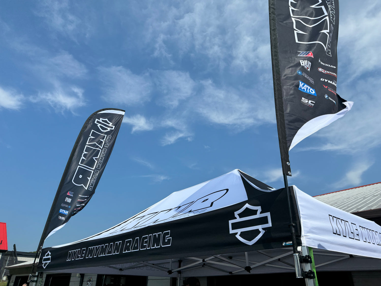 kyle wyman racing pit set up with wind flags and canopy designed by factoryfade